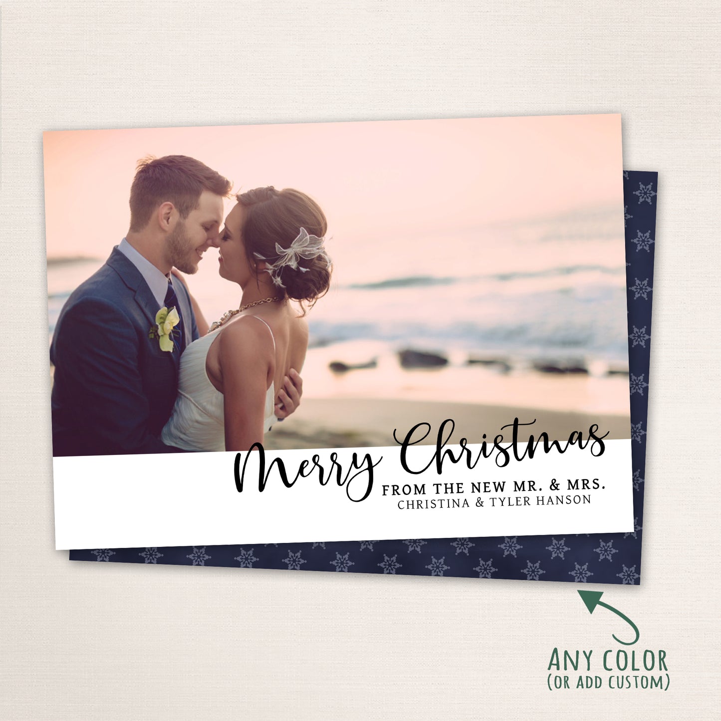 Newlywed couple embracing on the beach at sunset with “Merry Christmas” in modern black script and customizable background color.