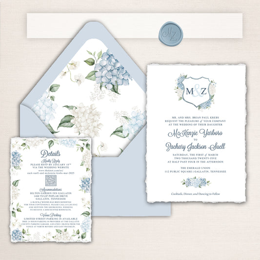 Wedding invitation suite with deckle edges. Design features blue and white hydrangeas, a custom crest, and matching envelopes, liners, and wax seal.