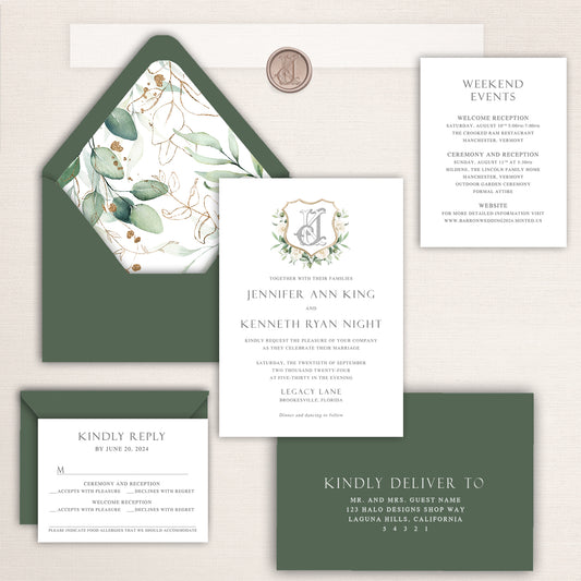 Wedding invitation suite featuring a custom crest, eucalyptus greenery design, and matching green envelopes.