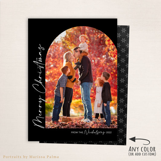 Modern family Christmas arch photo card featuring a tall vertical layout with “Merry Christmas” script text along the side, personalized family name, and a festive red patterned back. Custom colors available to match your holiday photo. Sample shown in black.
