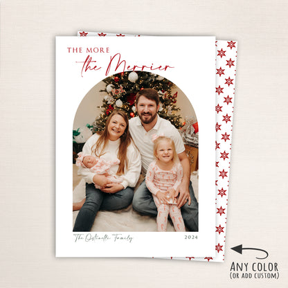 Personalized holiday card featuring a family photo under the heading “The More the Merrier,” with customizable colors, text, and year, and a red snowflake pattern back.