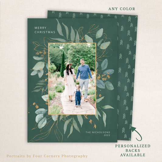 “Merry Christmas” eucalyptus photo card from Halo Design Shop featuring a modern botanical frame of soft green leaves and gold detailing, centered family photo, and customizable text. Includes personalized back options and any-color customization.