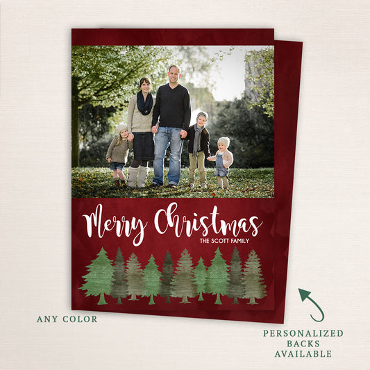 Merry Christmas holiday photo card with red background, watercolor pine tree border, and personalized family name.