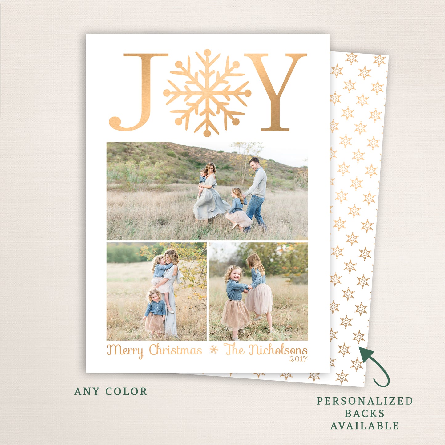 Elegant Christmas photo card with “JOY” in gold letters and a snowflake centerpiece, featuring three family photos below and an optional personalized back with a matching gold snowflake pattern.