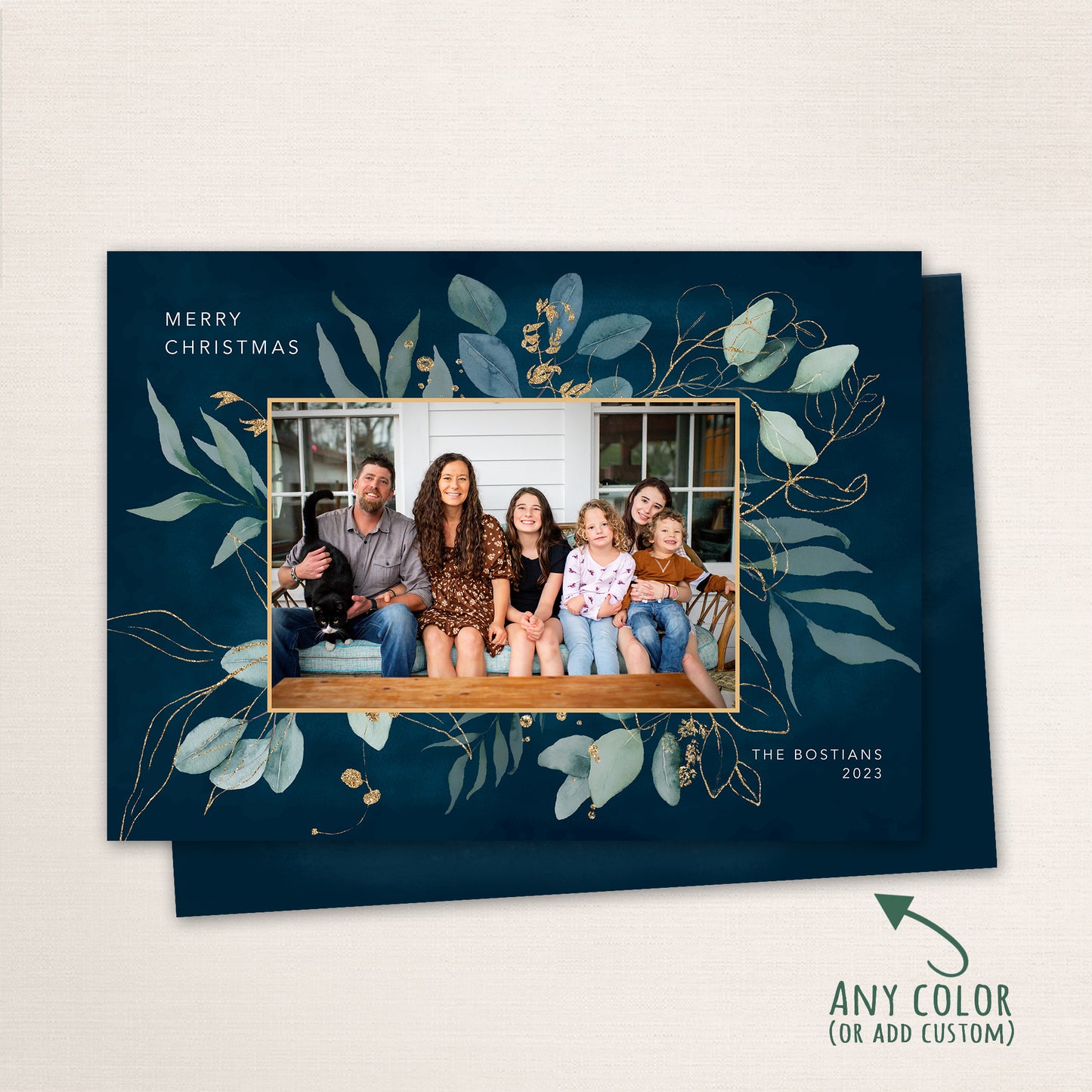 Navy blue holiday card with watercolor foliage and gold accents surrounding a family portrait, customizable with any color.