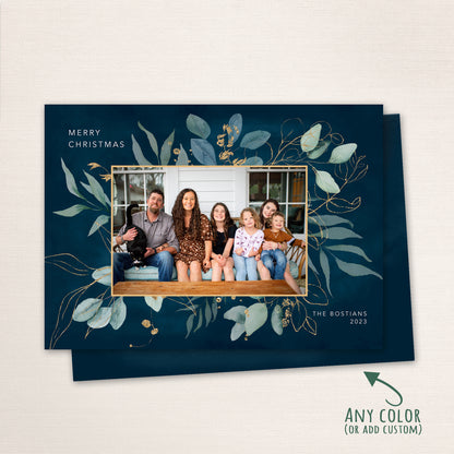 Navy blue holiday card with watercolor foliage and gold accents surrounding a family portrait, customizable with any color.