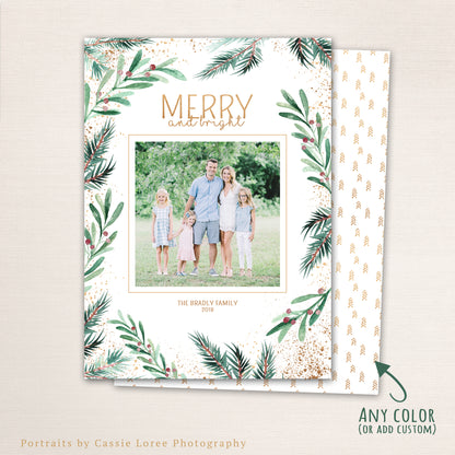 Elegant watercolor greenery Christmas photo card with “MERRY and bright” in gold text, pine and berry botanical border, and tree pattern back.