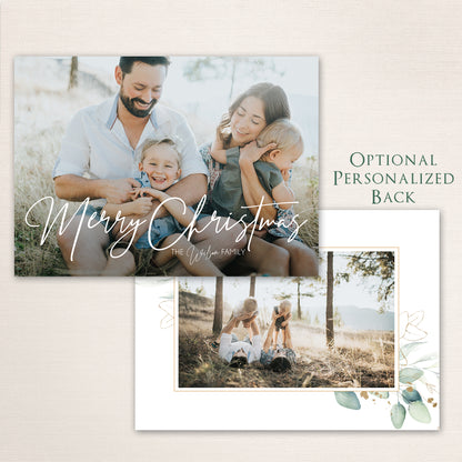 Horizontal Merry Christmas photo card with handwritten script typography, customizable text, and additional photo with a eucalyptus border on the back.
