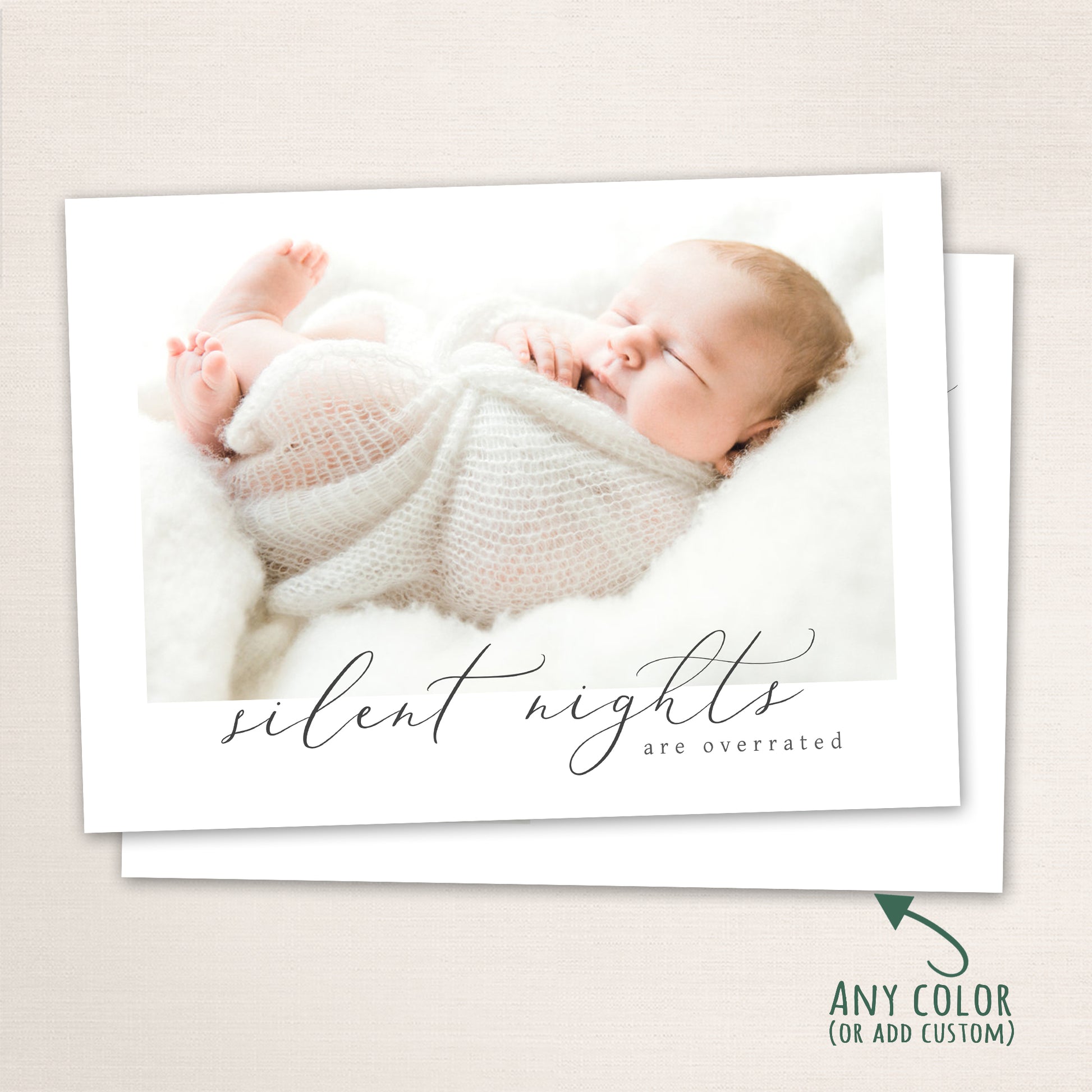 Sleeping newborn baby wrapped in a soft white knit blanket on a plush white background, with the phrase “Silent Nights Are Overrated” written in cursive script across the bottom.