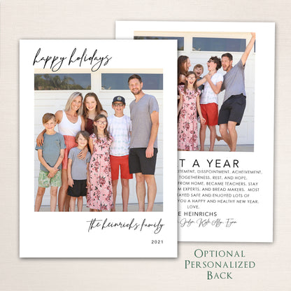 Modern Happy Holidays photo card from Halo Design Shop featuring a full-family photo on the front with minimalist black script typography and an optional personalized back for extra images or a written family update.