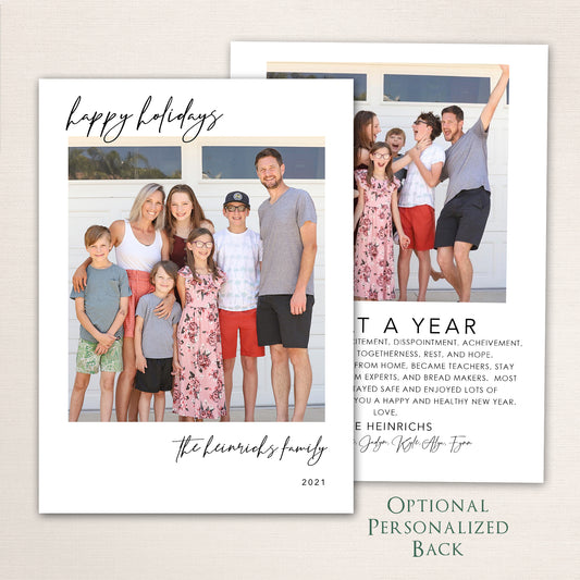 Modern Happy Holidays photo card from Halo Design Shop featuring a full-family photo on the front with minimalist black script typography and an optional personalized back for extra images or a written family update.