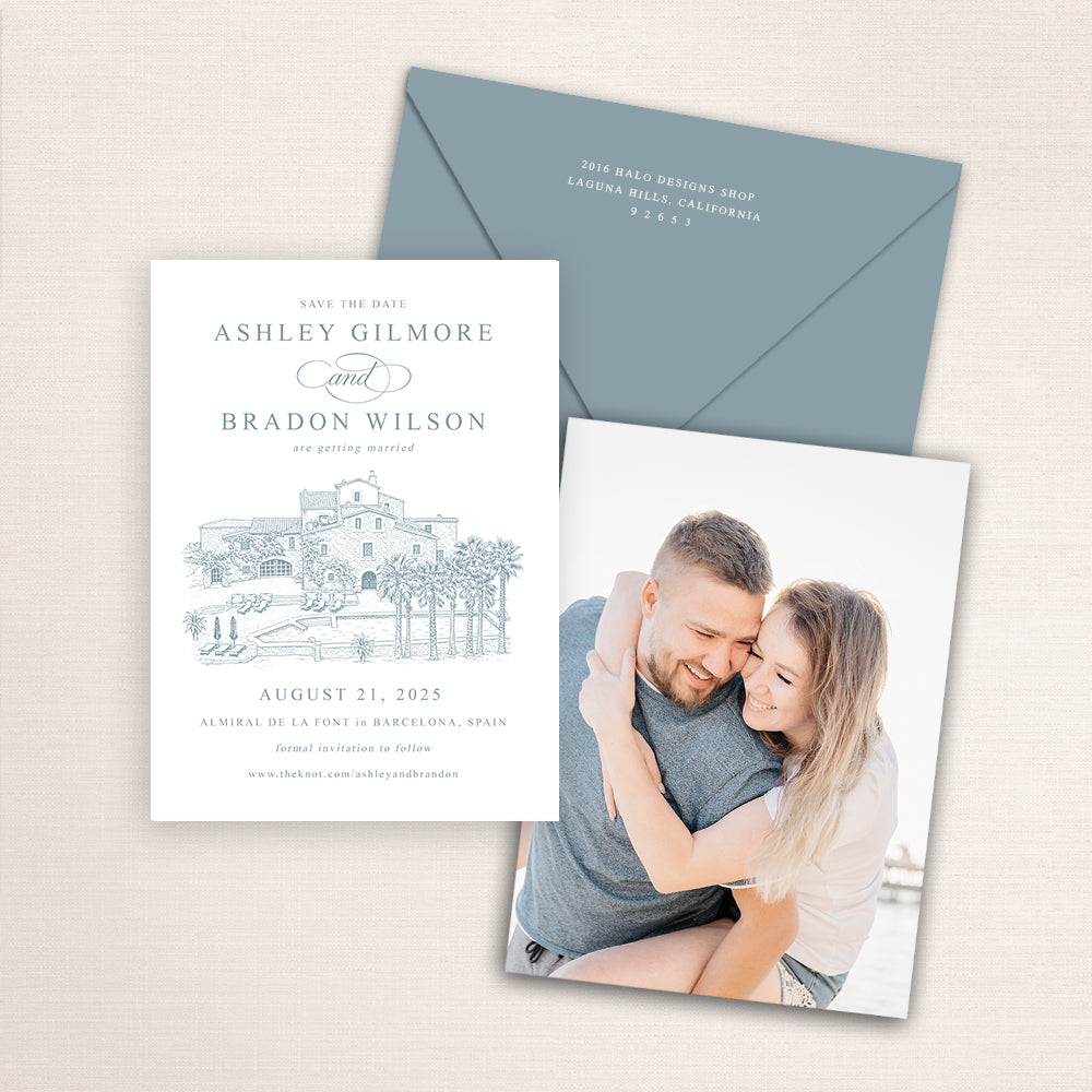 Almiral de la Font Barcelona save the date featuring a soft blue architectural line drawing of the Spanish villa, elegant typography, dusty blue envelope, and engagement photo on the back.