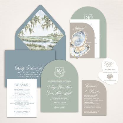Dusty blue and sage Charleston wedding invitation suite with custom watercolor marsh envelope liner, oyster shell artwork, arched monogram invitation, rehearsal dinner card, details card, and deckle edge QR code RSVP for an elegant Lowcountry wedding.