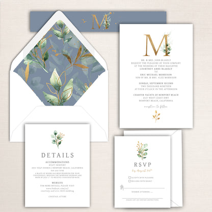 Gold monogram wedding invitation suite with watercolor greenery and soft blue accents, including invitation, RSVP, and detail cards with matching botanical envelope liner and monogram belly band.