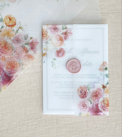 A vellum wrap for a 5x7 invitation that features shades of peach, pink, orange and dusty rose colored assortments of ranunculus, roses, dahlias, peonies, and poppies.