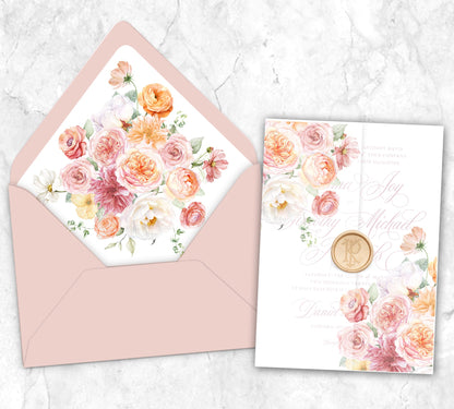 A vellum wrap for a 5x7 invitation that features shades of peach, pink, orange and dusty rose colored assortments of ranunculus, roses, dahlias, peonies, and poppies and a matching envelope liner and Cipria colored envelope.