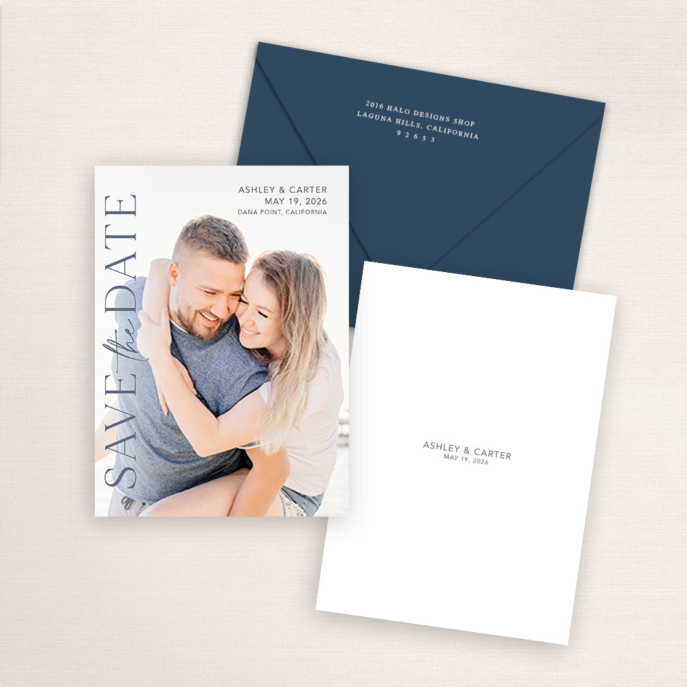 Modern vertical photo save the date suite with minimalist navy typography, matching navy envelope, and simple back design showing the couple’s names and wedding date in soft dusty blue text.